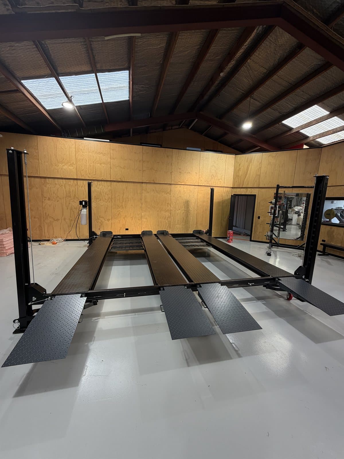 Black four-post hoists installed in a timber-framed shed